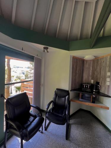 a living room with two chairs and a microwave at Ivybank Villa in Rothesay