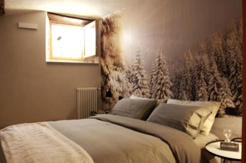 a bedroom with a bed with a snow covered wall at NEW Alpe Veille, Chalet Centro La Thuile 2 Bagni e Garage Privato in La Thuile