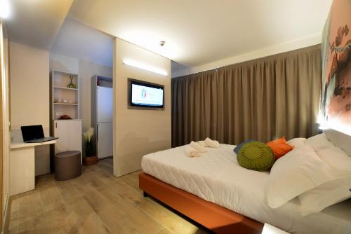 una camera d'albergo con letto e TV di Alla Pergola a Bibione