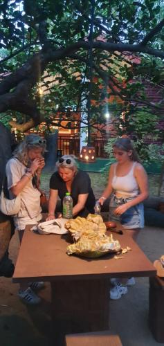 a group of women sitting around a table with food at Sigiriya Cashew Palace Resort in Sigiriya
