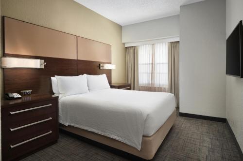 um quarto de hotel com uma cama grande e uma janela em Residence Inn Fort Lauderdale Plantation em Plantation