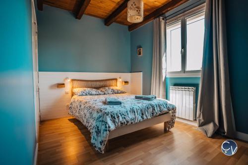 um quarto com uma cama com paredes azuis e pisos em madeira em Belle Villa au calme avec Superbe vue em Bagnols-sur-Cèze