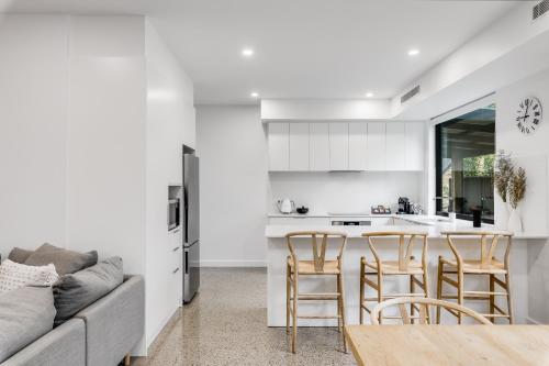 a kitchen and living room with a couch and a table at Vale 194 - Luxury Accommodation in McLaren Vale - 5 holiday homes with king size beds in McLaren Vale