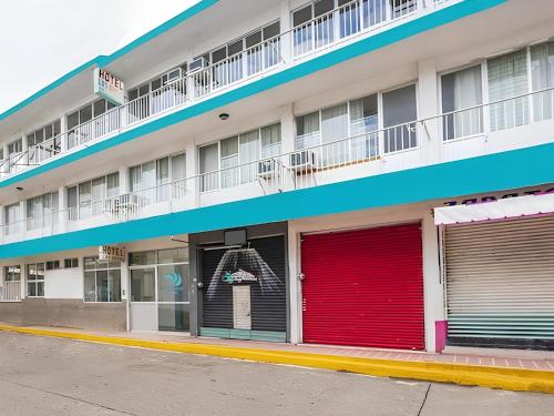 an apartment building with red garage doors at Hotel Las Brisas in Catemaco