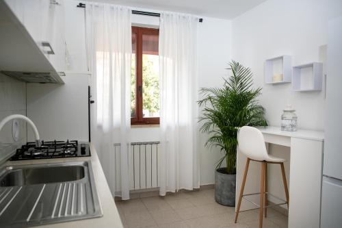 a white kitchen with a sink and a window at Apartment "Istra Inspirita II" in Rovinj