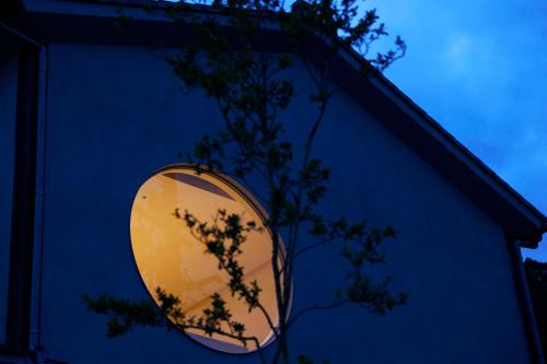 a round mirror on the side of a blue building at Tsuki to Maguro Ishigami in Yaizu