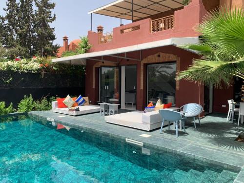 a villa with a swimming pool next to a house at La Villa 2A in Marrakesh