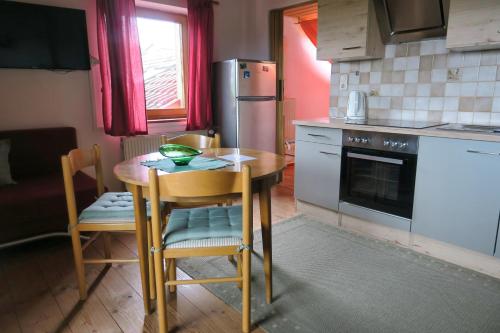 uma cozinha com uma mesa e cadeiras e um frigorífico em Ferienwohnung Degner em Schönberg