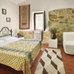a room with a bed and a table and a couch at Country House Il Sambro in Bettona