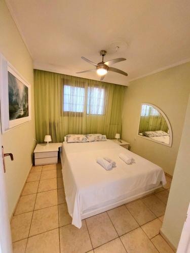 a bedroom with a bed and a ceiling fan at Anthi Apartment in Paleo Tsifliki