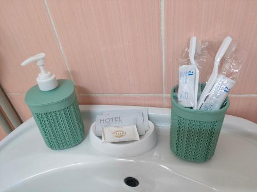 a bathroom sink with toothbrushes and a bottle of toothpaste at Galeto 22 Apartments in Semey