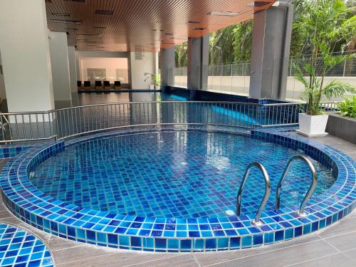 uma piscina com azulejos azuis num edifício em Ulike Homestay-3Room-4 king Size Bed-The Venus em Sitiawan