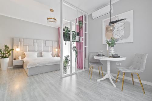 1 dormitorio blanco con 1 cama, mesa y sillas en Andreea Studio, en Oradea