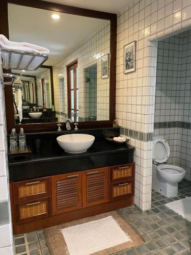 y baño con lavabo, aseo y espejo. en Ban Na, en Satuk