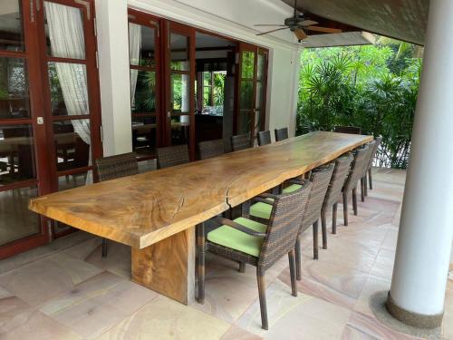 un tavolo in legno con sedie intorno su un patio di Ban Na a So Tuk