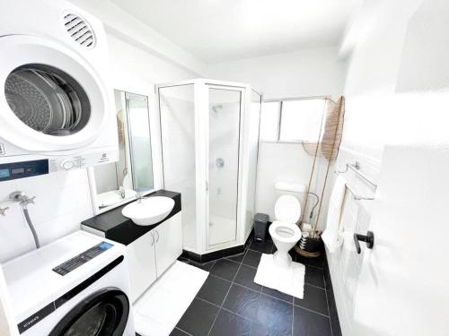 Baño blanco con aseo y lavamanos en Gladstone Gem 7 - Suva CBD 2bdrm Apartment en Suva