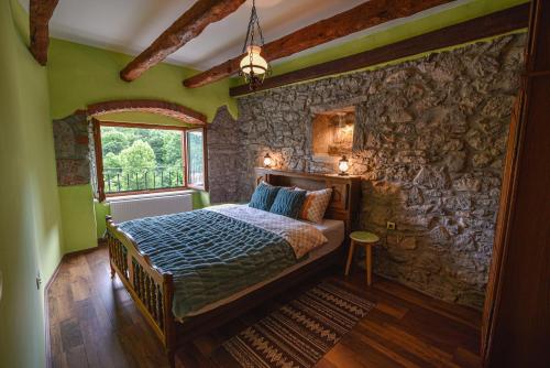 a bedroom with a bed and a stone wall at Villa Danica with pool - Perka in Zvoneće