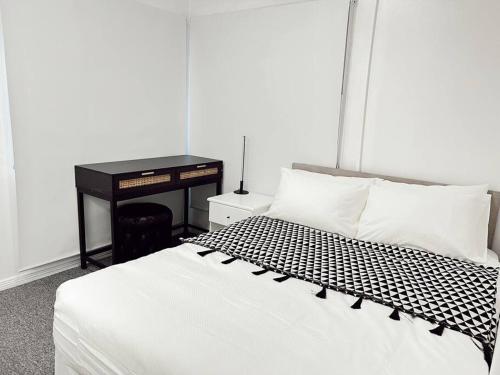 una camera da letto con un letto con un piumone bianco e nero di Gladstone Gem 7 - Suva CBD 2 Bedroom Apartment a Suva