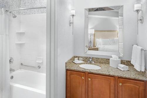 een badkamer met een wastafel, een bad en een spiegel bij Residence Inn by Marriott West Orange in West Orange