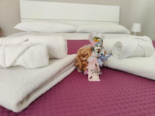 Un perro de peluche está sentado junto a dos camas. en Apartments for rent Catania, en Catania