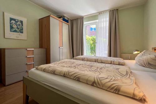 1 dormitorio con 2 camas y ventana en Ferienwohnung-9-mit-Schwimmbad-Sauna-Residenz-Passat-Doese, en Cuxhaven