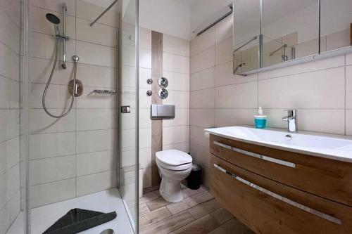 y baño con aseo, lavabo y ducha. en Ferienwohnung-9-mit-Schwimmbad-Sauna-Residenz-Passat-Doese, en Cuxhaven