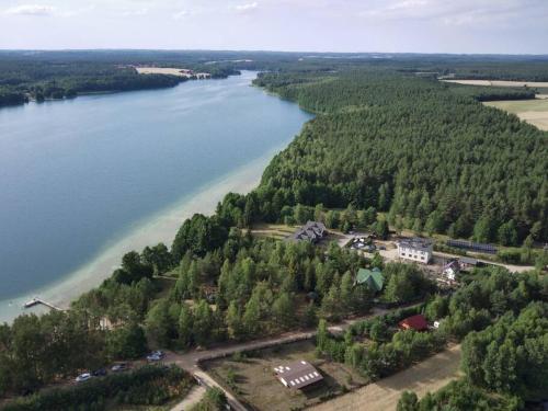an aerial view of a river and a house at Borowa Chatka in Borowy Młyn