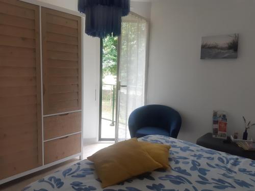 una camera con un letto e una sedia e una finestra di Chambre d'hôte cosy & zen a Saint-Jean-la-Poterie