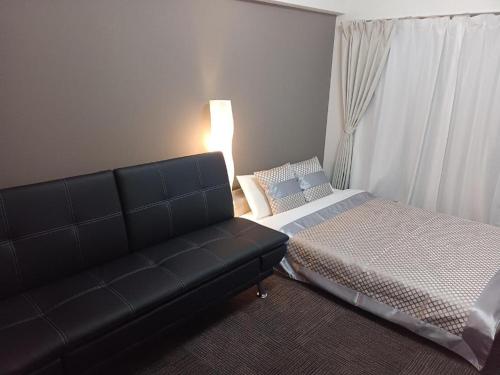 uma sala de estar com um sofá e uma cama em Cocostay The Peace Memorial Park ココステイ平和記念公園 em Hiroshima