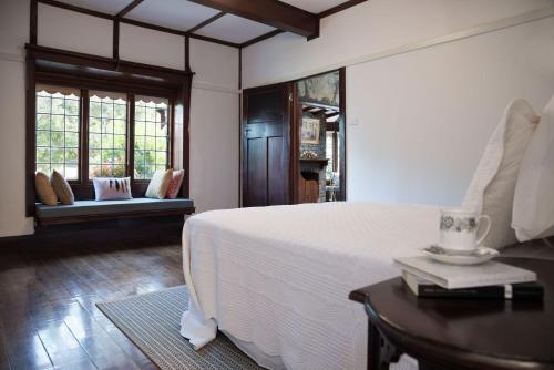 a bedroom with a bed and a table with a book at Zelman Cottage in Hepburn Springs