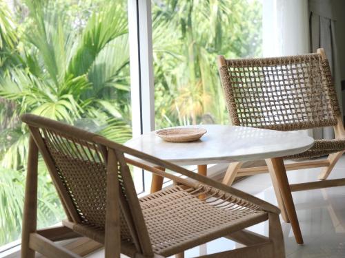 a table and two chairs in front of a window at Karon beach apartment & sea view pool in Karon Beach
