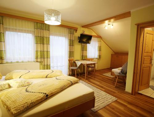 um quarto com 2 camas e uma sala de jantar com uma mesa em Haufhof-Pension am Bauernhof, Haus im Ennstal bei Schladming em Haus im Ennstal