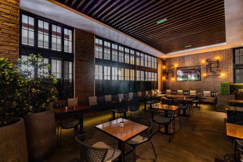 a restaurant with tables and chairs and windows at Amwaj Rotana, Jumeirah Beach - Dubai in Dubai