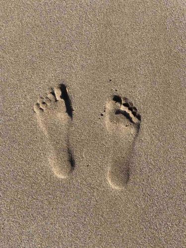 a pair of feet in the sand on the beach at Khroma Luxury Suite 2 Beach front apartment in Hersonissos