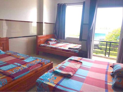 1 Schlafzimmer mit 2 Betten und einem Fenster mit Aussicht in der Unterkunft Nhà Nghỉ Cẩm Tiên 1 in Hà Tiên