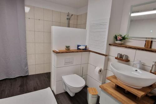 a bathroom with a white sink and a toilet at Idyllischen Ferienwohnung mit Weitblick und Sauna in Schnaittach