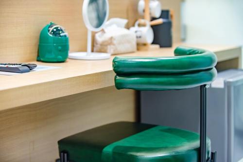 a green chair sitting in front of a counter at Long Stay Here in Tainan