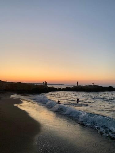 a group of people in the water at the beach at Khroma Luxury Suite 2 Beach front apartment in Hersonissos