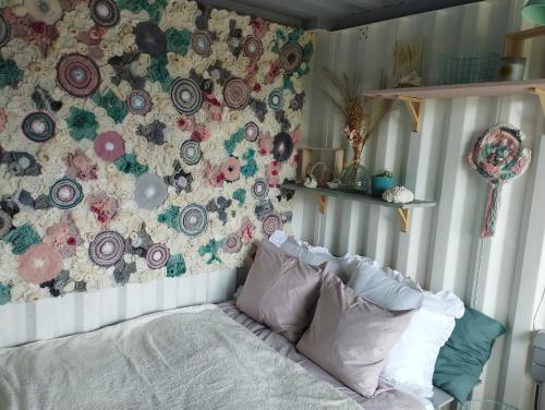1 dormitorio con una pared de flores y 1 cama en la parte delantera en La cabane du berger du parc national ESM, en Froidchapelle