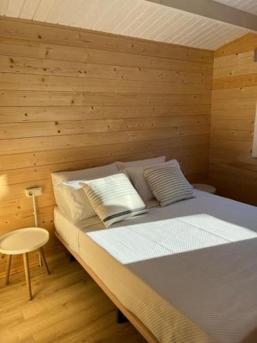 a bedroom with a bed with a wooden wall at Casas de A Uriceira in Cangas de Morrazo