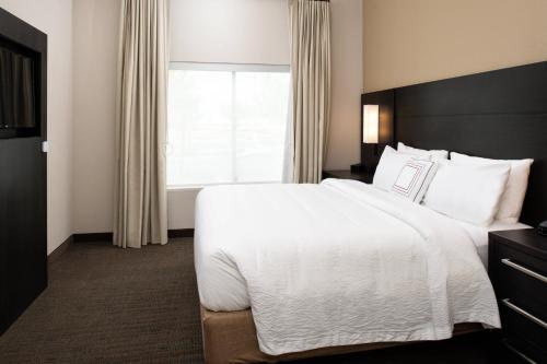 um quarto de hotel com uma cama grande e uma janela em Residence Inn Visalia em Visalia