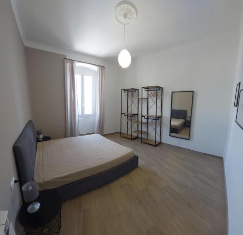 1 dormitorio con 1 cama grande y espejo en FIUMARA MALL Apartment, en Génova