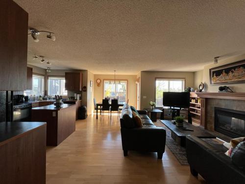 a living room with a couch and a kitchen at Spacious comfortable Air-Conditioned. Near airport! in Calgary