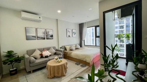 a bedroom with a bed and a couch and a table at Vinhome Smartcity - Căn hộ cao cấp full tiện ích TTA in Hanoi