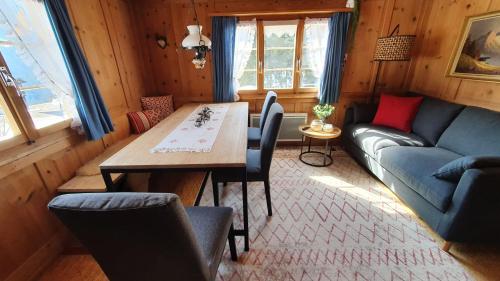 ein Wohnzimmer mit einem Tisch und einem Sofa in der Unterkunft Charming Chalet with mountain view near Arosa for 6 People house exclusive use in Langwies