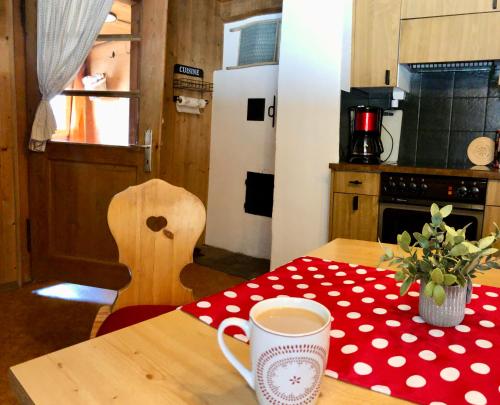 una cocina con una mesa con una taza de café. en Charming Chalet with mountain view near Arosa for 6 People house exclusive use, en Langwies