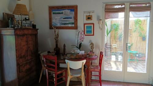 a dining room with a table and red chairs at Maison Candide 3 chambres 1 mezzanine in Capbreton