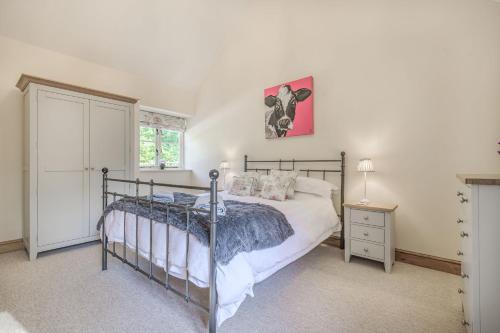 ein Schlafzimmer mit einem Bett und einem rosa Bild an der Wand in der Unterkunft Old Farm Stables in Yeovil