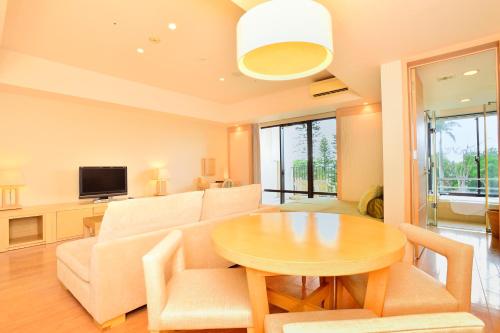 a living room with a table and a couch at Moon Ocean Ginowan Hotel & Residence in Ginowan
