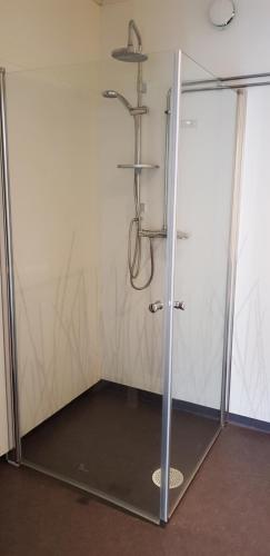 a shower with a glass door in a room at Cabin located in a traditionally Swedish setting! in Umeå